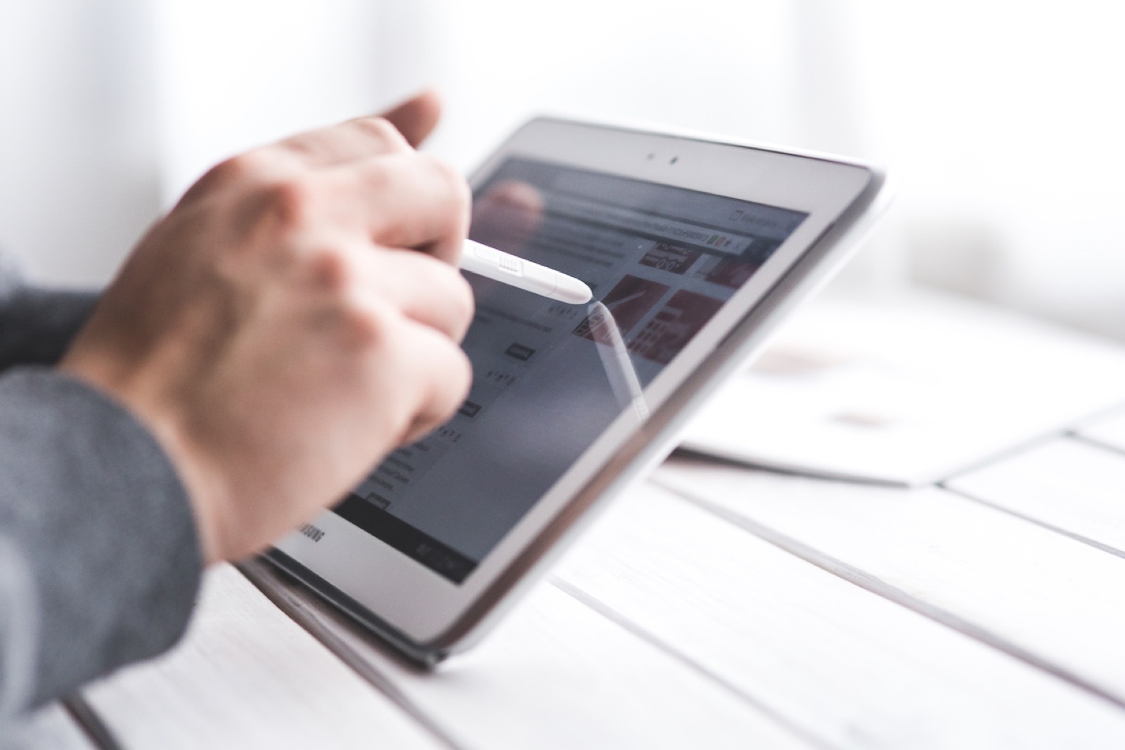 Main tenant un stylet au-dessus d'une tablette